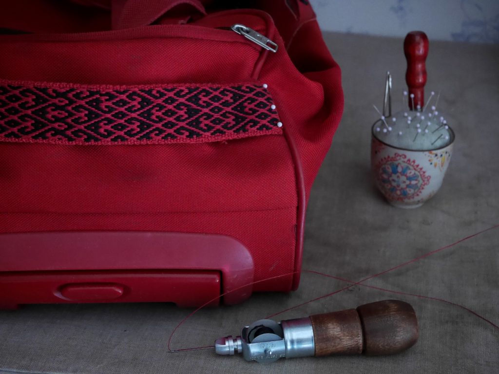 réparer un bagage abîmé avec un tissage artisanal sur métier à bandes
